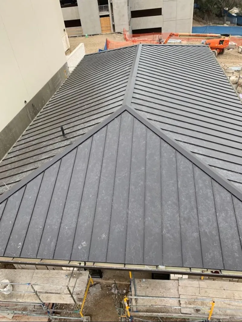 Commercial metal roof construction with crane equipment in Woodhaven